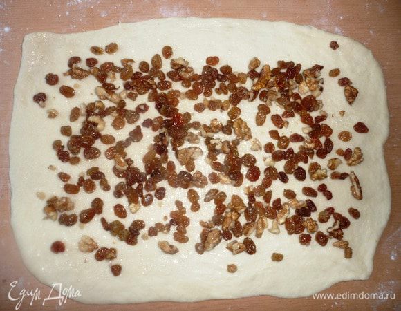 Выложить орехи и изюм на пласт теста