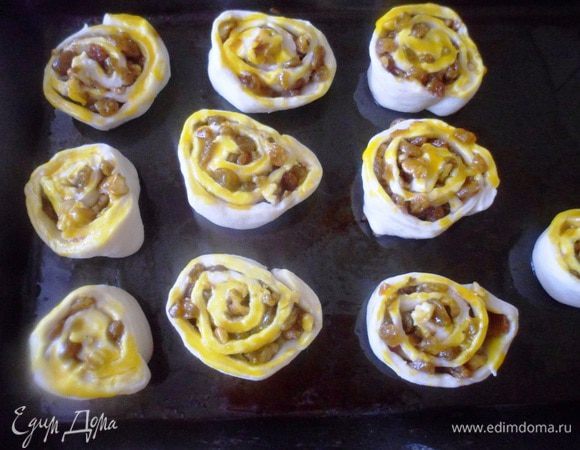 Выложить плюшки на противень смазанный маслом, смазать желтком и поставить в горячую духовку, выпекаться на 15 минут.