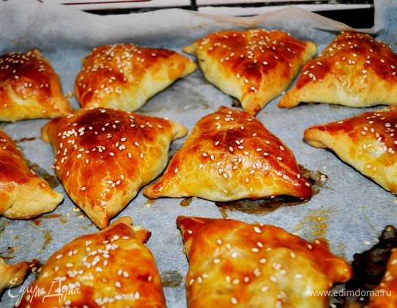 Разрезать каждый пласт на 8 частей,раскатать каждый в круг.
В центр круга выложить по 2 столовой ложки начинки и защипать края так, чтобы получился треугольник.
Противень накрыть бумагой для выпечки.
Уложить самсу швом вниз, смазать слегка взбитым яйцом, посыпать кунжутными семечками.
Поставить в духовку, на 35-40 минут при 180-200С.
Выпекать до золотистого цвета.