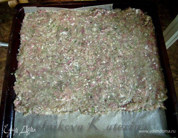 Противень выстелить пекарской бумагой, смазанной сливочным маслом. Выложить на противень мясной фарш, разровняв его (я делала на 3/4 противня, иначе он получился бы слишком длинным). Отправить выпекаться на 30 минут при 180 градусах.