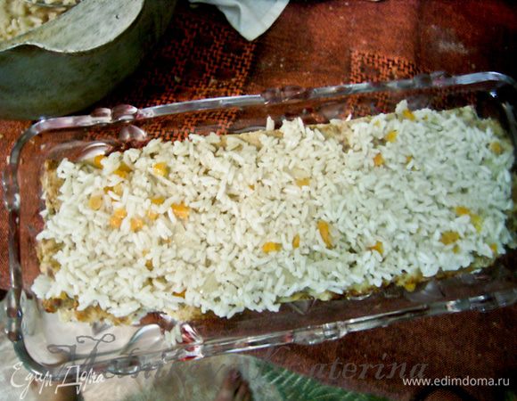 Теперь сборка. На блюдо выложить мясной корж. На него выложить рисово-овощную начинку толщиной примерно 0,5 см, разровнять по всей поверхности коржа. 