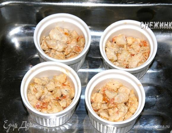 Порционные керамические формочки смазать сливочным маслом. Выложить куриное филе.