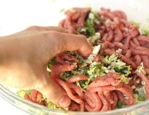 Пропускаем через мясорубку, натираем на тёрке ингредиенты: капусту, зеленый лук, чеснок, имбирь. Перемешиваем измельчённые ингредиенты c свиным фаршем в большой миске (руками).