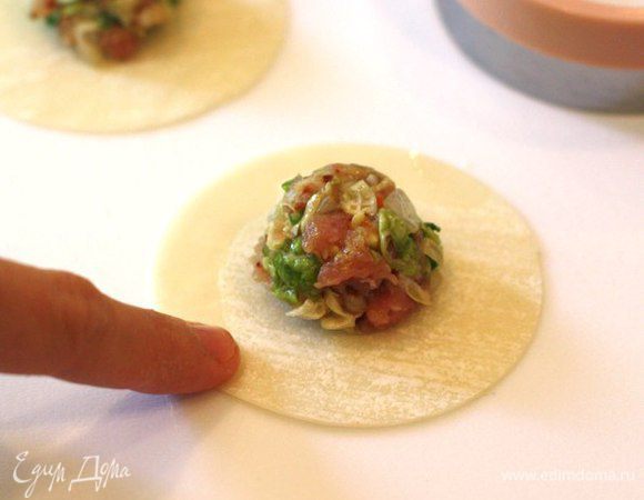 Лепим пельмени. Добавляем немного мясной смеси в центр кружочка теста.