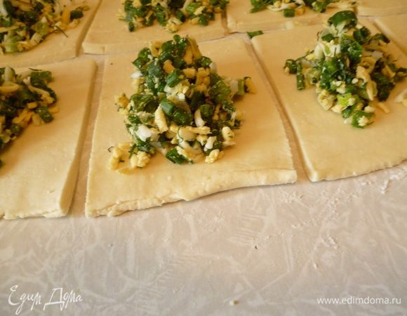 Тесто разрезать на две части,одну убрать в холодильник.Кусок теста раскатать в пласт толщиной 4-5мм(срез теста должен быть сбоку).Если есть место,то можно раскатать сразу весь кусок теста,не деля его пополам.И теперь есть два варианта:можно разрезать на квадраты примерно10Х10см