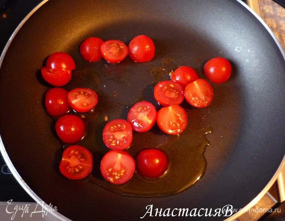Томаты-черри промыть и разрезать на половинки. Обжарить в оставшемся оливковом масле в течение 3-х минут.