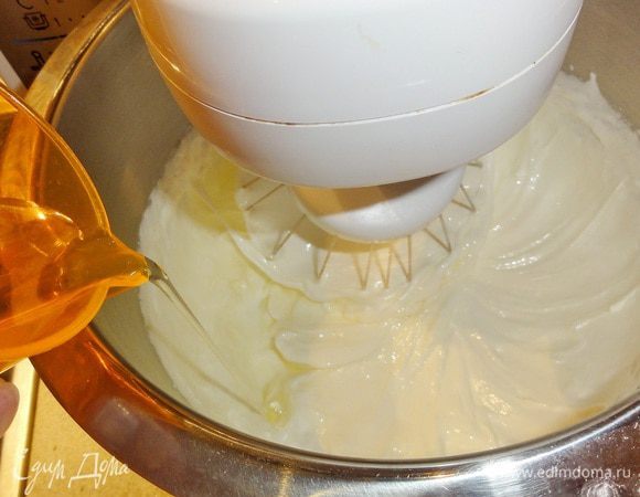Убавьте скорость, влейте масло, воду, а затем и цедру с ванилью. Увеличьте скорость и взбейте массу до густоты.