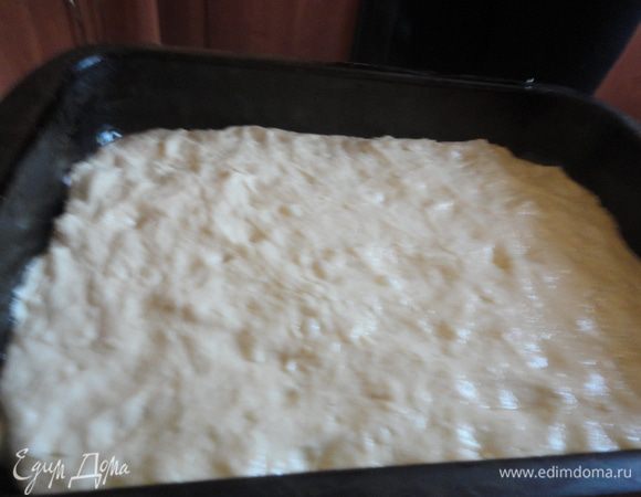 Взять противень с высокими бортами, смазать растительным маслом.
Разровнять тесто руками по всему противню.