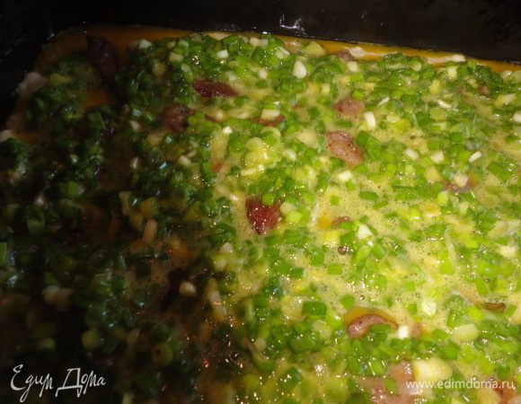 На свинину вылить яйца с зеленым луком. Поставить в разогретую духовку на 30 - 35 минут.