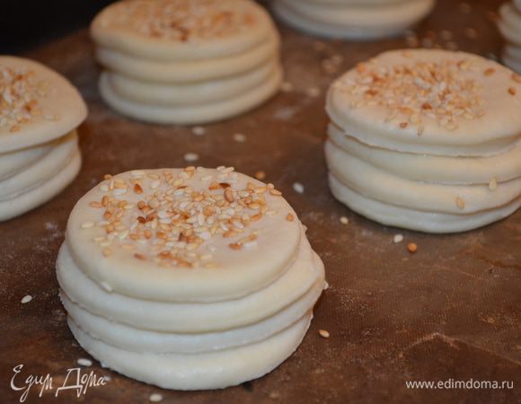 Ставим булочки на противень, застеленный бумагой (бумагу смазать малом - иначе прилипнут), верх также смазываем водой и присыпаем кунжутом. Оставляем отдохнуть на 45 минут. 