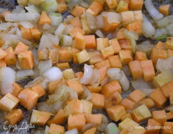 В сковороде на оливковом масле обжарить мелко нарезанный лук, добавить нарезанную маленькими кубиками морковь.