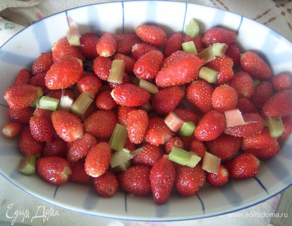 Клубнику промыть, выложить в форму для запекания ровным слоем, нарезать маленькими брусочками ревень. 