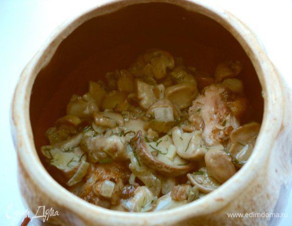 Выложить крылышки на дно горшочков, свержу грибы и мелко порезанный чеснок.