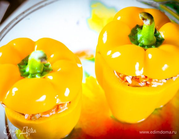 Перцы вымыть, срезать крышечку, удалить семена. Нафаршировать перцы, выложить их в форму для запекания. Форму наполовину залить горячей водой, добавить щепотку паприки.