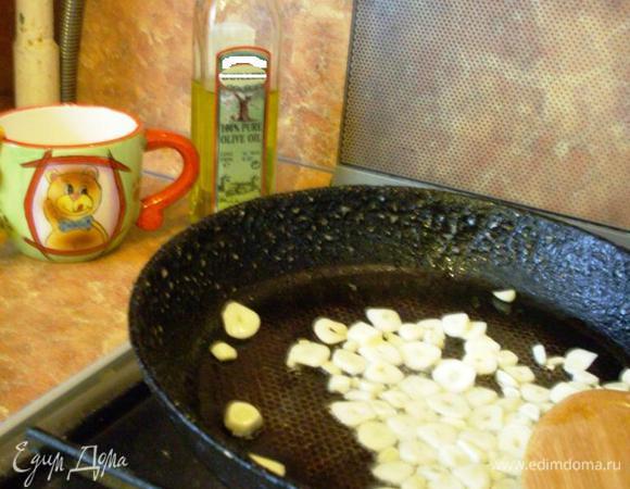 Чеснок режем кружочками и обжариваем на сковородке на оливковом масле 1-2 минуты. Перекладываем в форму для запекания.