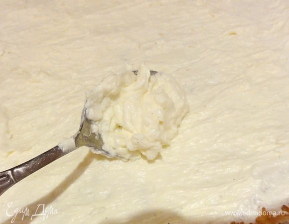 Половину крема выложите на первый корж.