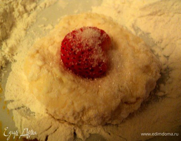 Ложкой отделить кусочек теста, скатать шарик, сделать по-середке углубление. Положить клубничку, посыпать немного сахаром.                                                                                            