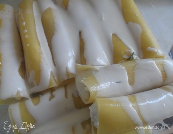 В форму выложить фаршированные каннелони, залить равномерно сливками.