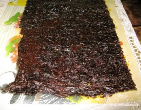 Расстелить на столе пищевую пленку. Выложить на нее 2 листа Нори, смочить слегка водой и "склеить" их немного внахлест. Вот что получится.