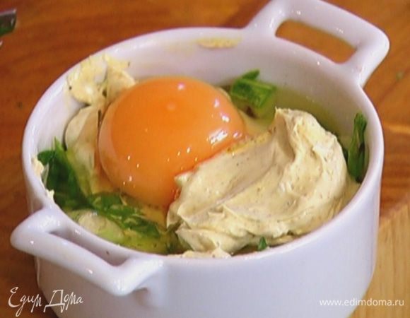 Влить в каждую форму по 1 ч. ложке сметанного соуса, равномерно распределить, а сверху разбить по яйцу так, чтобы желток не растекся. Добавить еще по 1 ч. ложке соуса, немного посолить.