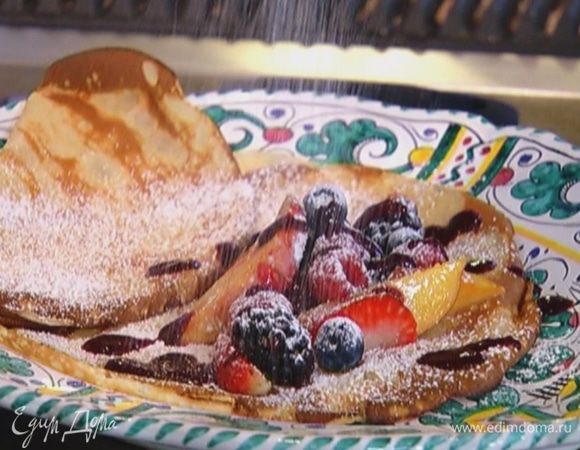 На каждый блин выложить немного начинки из ягод с персиком, малину, голубику, полить ягодным соусом и присыпать оставшейся сахарной пудрой.