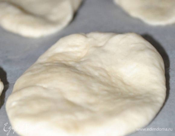 Духовку нагреть до 200 гр.
Сжать ладонями шарики так, чтобы они превратились в лепешки. Положить их на противень, наколоть вилкой, смазать оливковым маслом.