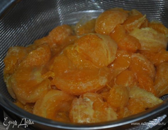 Мандарины очистить, разделить на дольки. Сложить в кастрюлю, добавить сахар, воду и поставить на огонь. Довести до кипения и варить на медленном огне 10 минут.
Откинуть на дуршлаг.