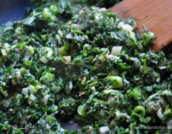 На сковороде разогреть масло, обжарить луковицу. Всыпать зелень, держать на огне, помешивая, до мягкости.
Влить взбитое яйцо, быстро перемешать. Отключить огонь.