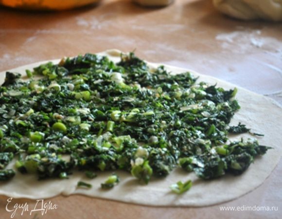 Разделить тесто на 8 частей. На каждый лаваш у нас уйдет 2 кусочка теста. Будет 4 лаваша. 
2 кусочка теста тонко раскатать, положить четвертую часть начинки, разровнять ее по поверхности теста.