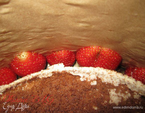 В пространство между тортом и бортиками формами положить половики клубники, срезом к бортику.