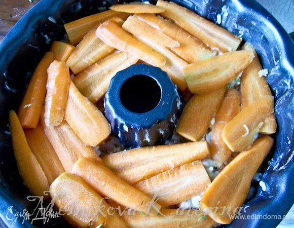 На шампиньоны выложить слой моркови, нарезанную пластинами. 