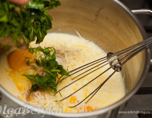 Влить молоко, перемешать. Добавить желтки, сыр, мелко порезанные укроп и петрушку, соль и перец. Снять с огня.
