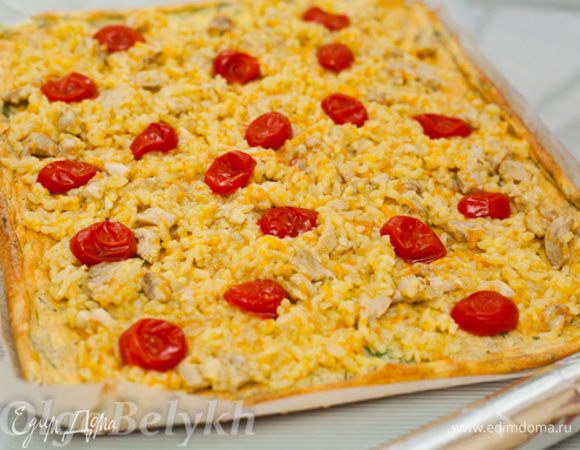 На остывшем омлетном корже равномерно распределить остывшую начинку из риса и курицы. Аккуратно разложить половинки помидоров. 