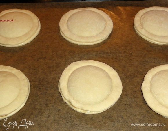 Выложите пироги на противень, застеленный пергаментной бумагой и уберите в холодильник на 15 минут. Нагрейте духовку до 200 градусов.