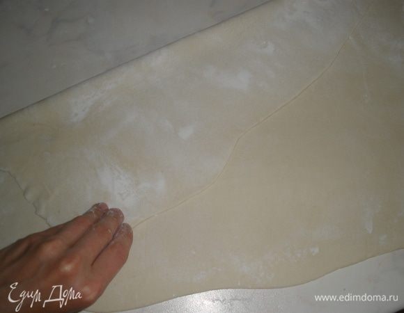 Тесто разморозить и раскатать в пласт (прямоугольный), толщиной 3 мм. Сложить его попалам. То есть дальний край загнуть к себе. Получится длинный прямоугольник. 