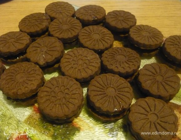 Половину печенья (у меня было круглое, но думаю, что его форма не принципиальна) смазать вареньем(конфитюром) и накрыть оставшимся печеньем.