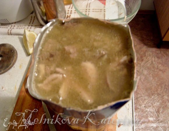 Теперь нужно подготовить тару для сальтисона. Для этого взять коробку от сока типа Tetrapak, срезать ножницами верхушку с крышкой. Все мясо выложить в коробку и утрамбовать. Залить мясо бульоном. Бульон нужно заливать частями, осторожно надавливая на стенки коробки пальцами, давая бульону проникнуть внутрь. Бульон залить доверху, он потом еще со временем впитается. 