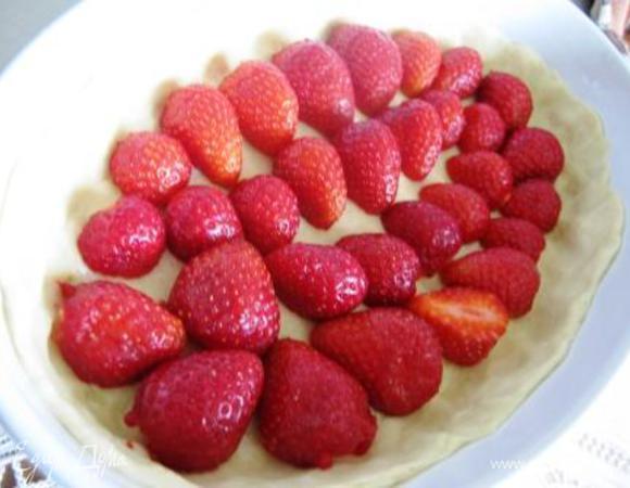 Тем временем помыть и обсушить клубнику, разрезать пополам. Оставить несколько ягод для подачи (я оставила, но пока охлаждался пирог, она улетучилась). Достать тесто и уложить на него клубнику.