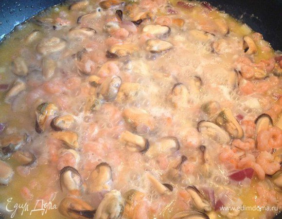 Добавляем морепродукты, мелконарубленный чеснок и белое вино. Даем спирту выпариться.