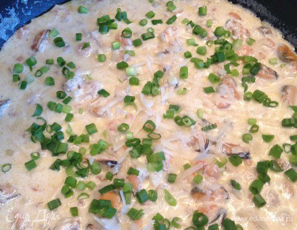 Посыпаем готовое блюдо тертым пармезаном и зеленым луком.