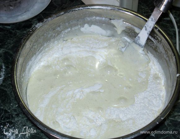 Ввести просеянную муку постепенно, перемешивать медленно, плавно, лопаткой снизу вверх, меняя слои(уложиться в 5 минут). Аккуратно вылить тесто в форму, слегка распределить его от центра к краям.