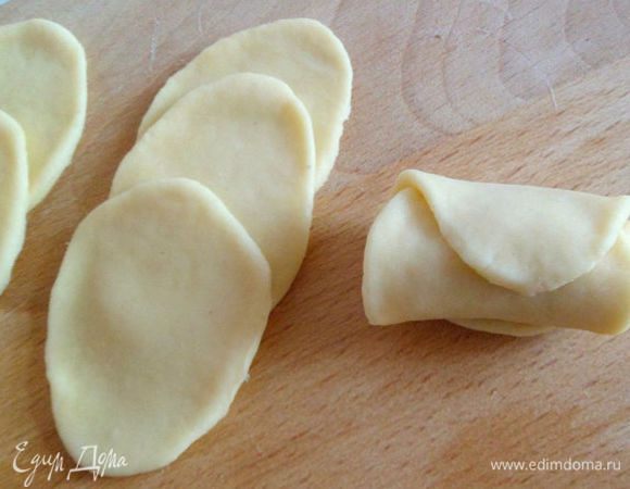 Выложить три овала из теста внахлест друг на друга и скатать в рулетик