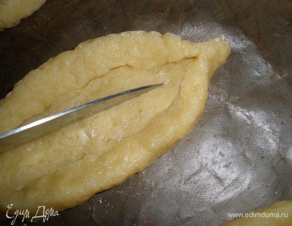 Вдоль всего печенья сделать неглубокий надрез ножом. Переложить их на противень, застеленный промасленной бумагой для выпечки. Оставить на 1 час, печенье должно немного "заветриться".