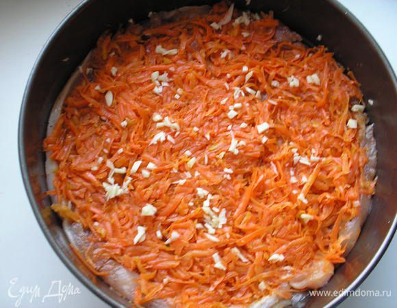 Выкладываем на куриное филе морковь. Морковь посыпаем рубленым чесноком.