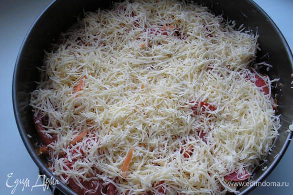 Сыр натираем на терке. Посыпаем помидоры сыром. Немного сыра оставляем для посыпки пирога.