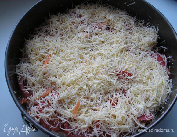 Сыр натираем на терке. Посыпаем помидоры сыром. Немного сыра оставляем для посыпки пирога.