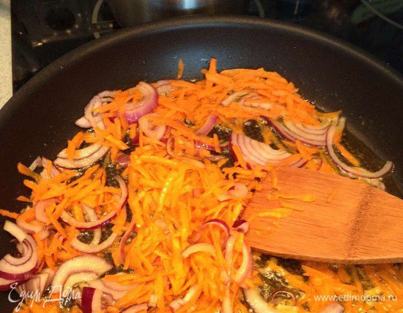 В сковороду (лучше вок или казан) наливаем оливковое масло. Когда масло раскалится добавляем нарезанный кольцами лук и натертую морковь.