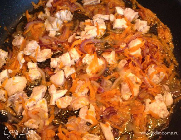 Куриные бедрышки режем не слишком мелко и отвариваем (нам понадобится куриный бульон). Отварные бедрышки добавляем к луку и моркови. Обжариваем все вместе в течение 10-15 минут на среднем огне.