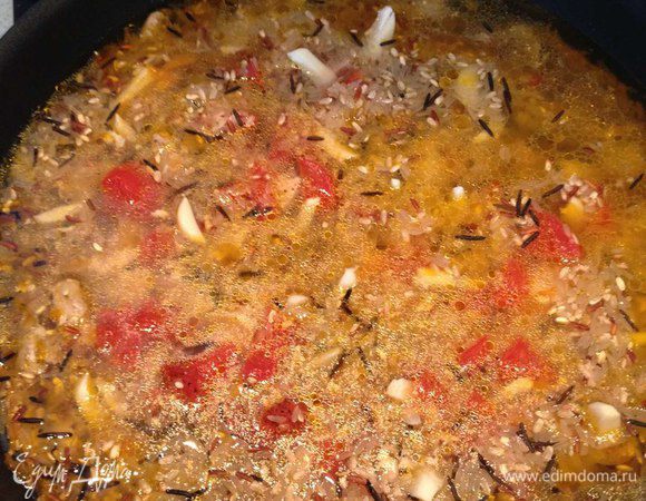 Рис заливаем куриным больоном. Накрываем крышкой и тушим в течение 35 минут.