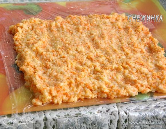 Подготовим рабочую поверхность. На стол или доску кладем пищевую пленку. Немного сбрызгиваем водой. Распределяем «тесто» в виде прямоугольника. 